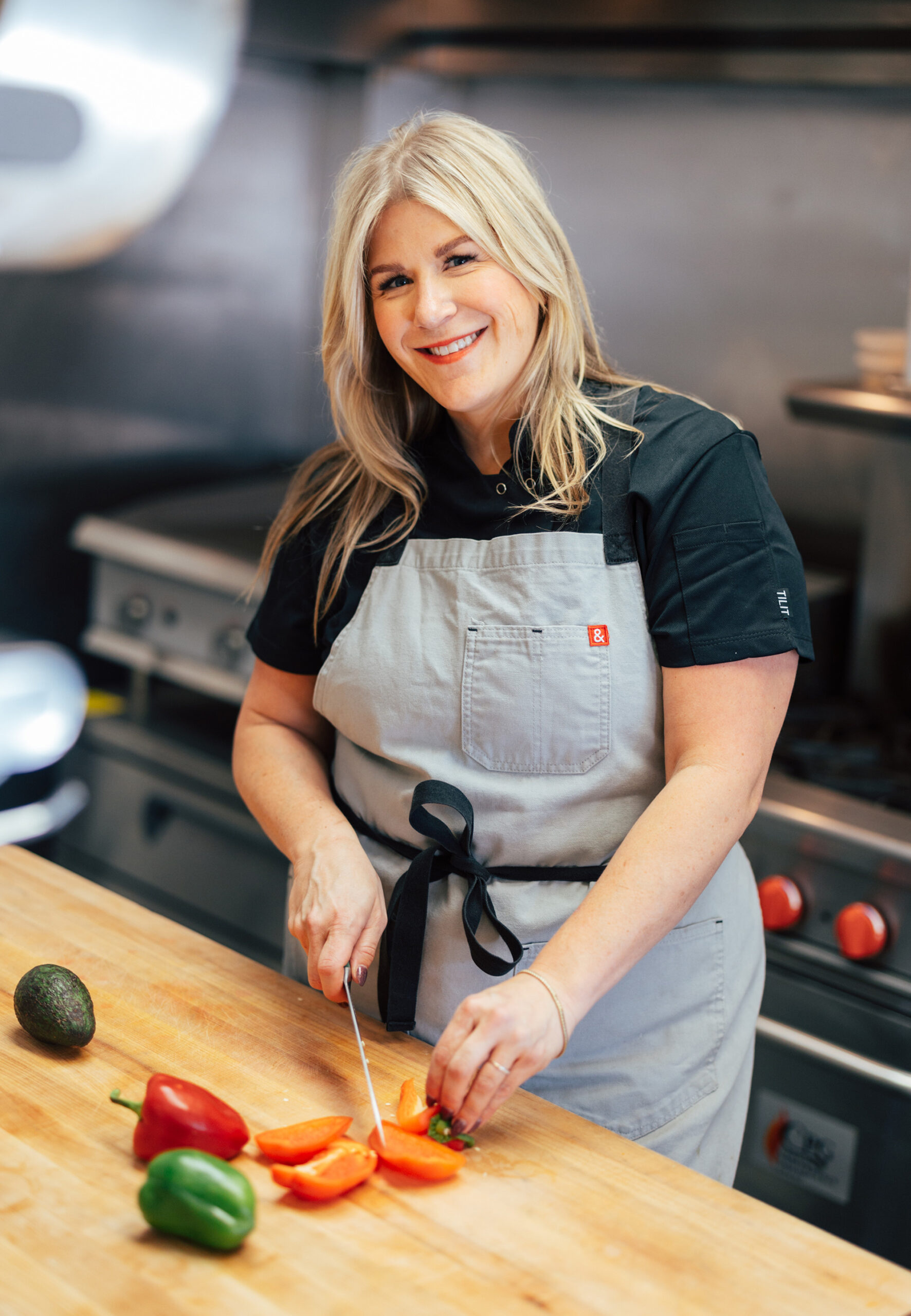 Lindsey Noto King chops peppers in a commercial kitchen