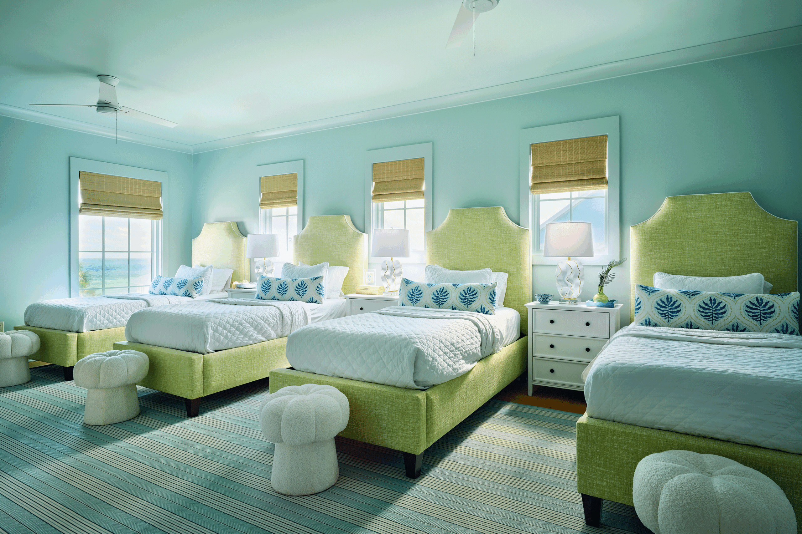 Spacious children's bedroom featuring a row of four custom twin beds to maximize sleeping capacity while sharing a vacation home.