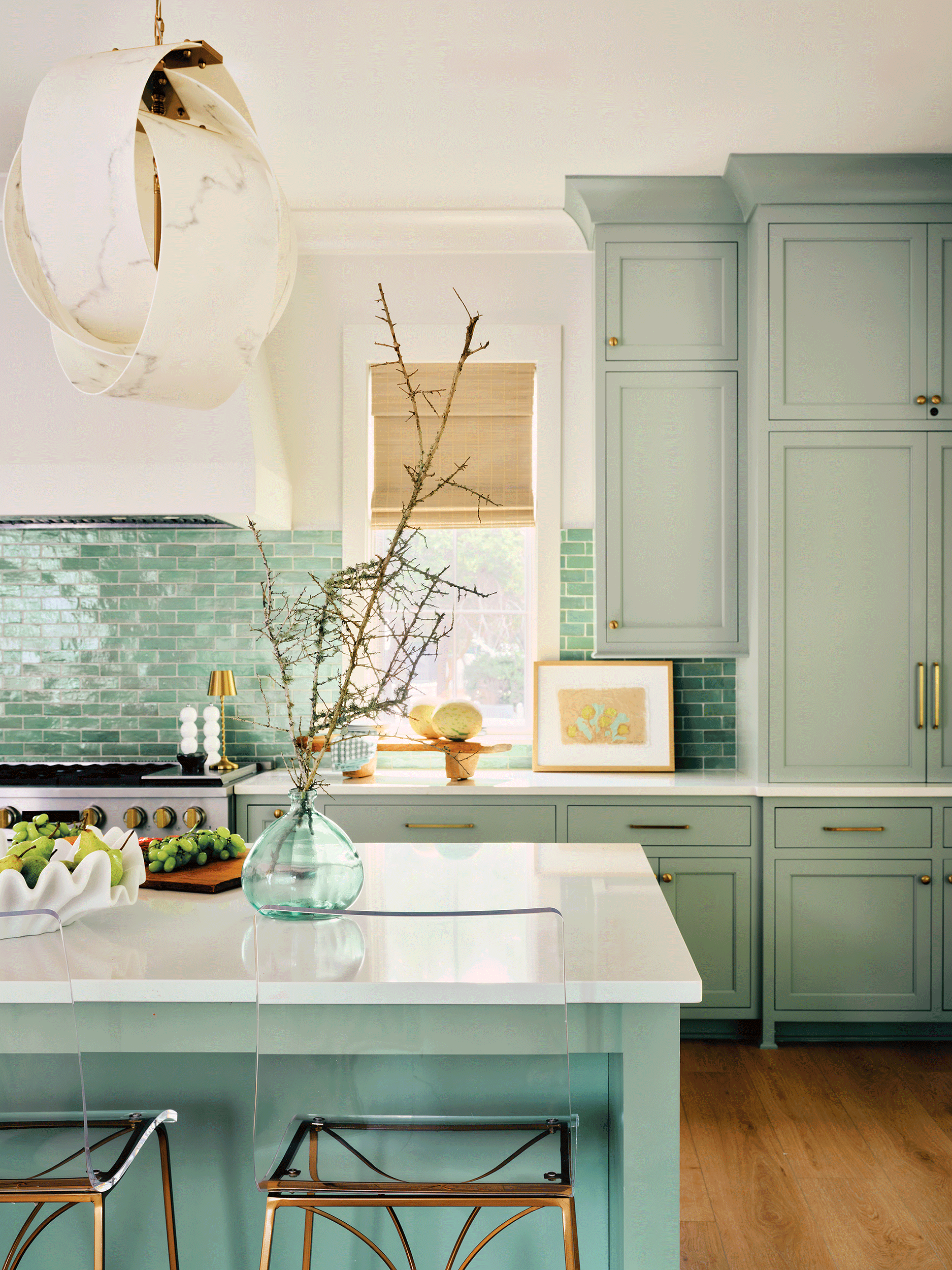 Beach house kitchen with seafoam cabinets and marble island designed for large groups.