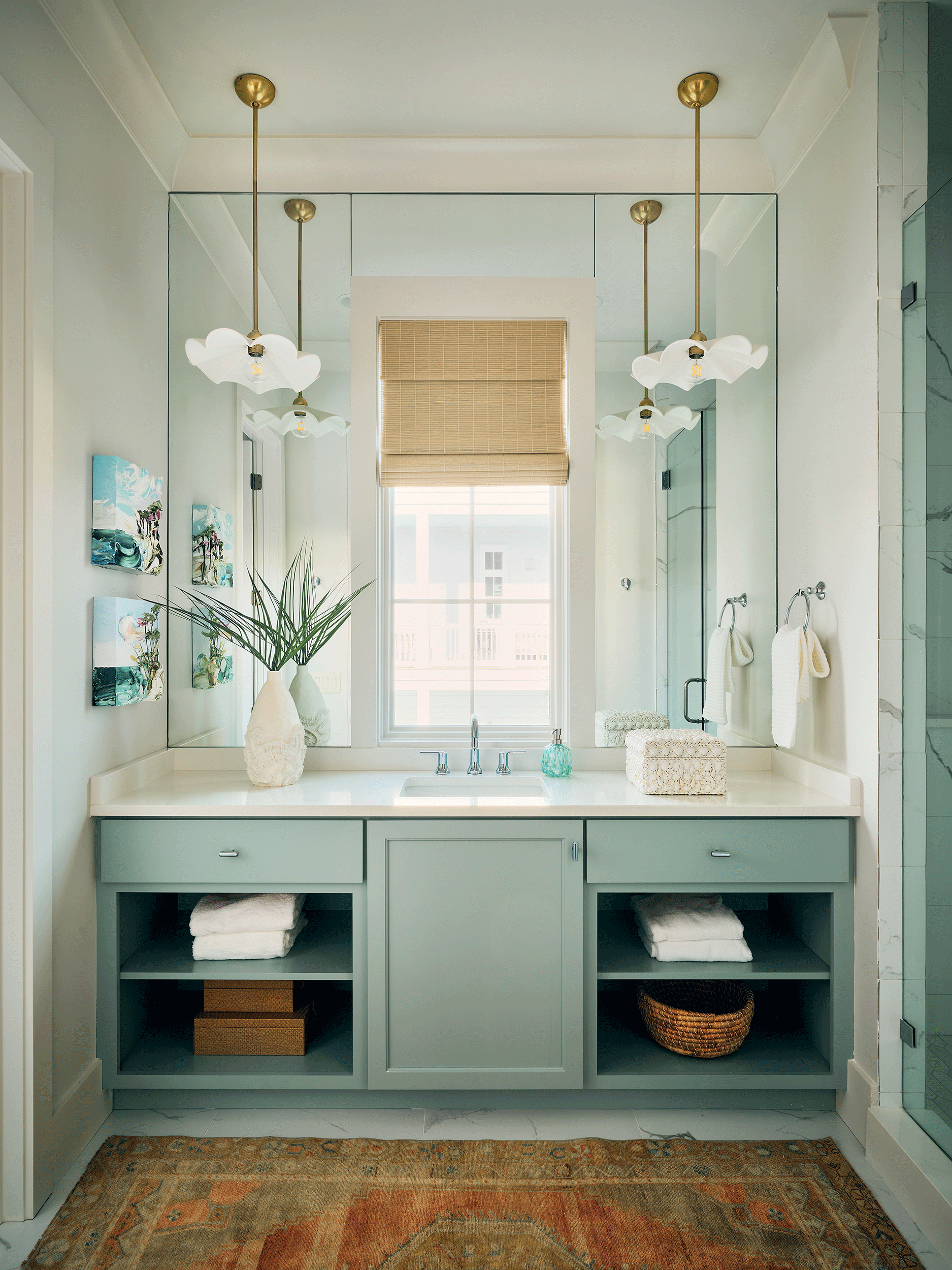 Blue-themed owner's suite bathroom in a beach house with a double vanity and coastal decor for a private couple's retreat.
