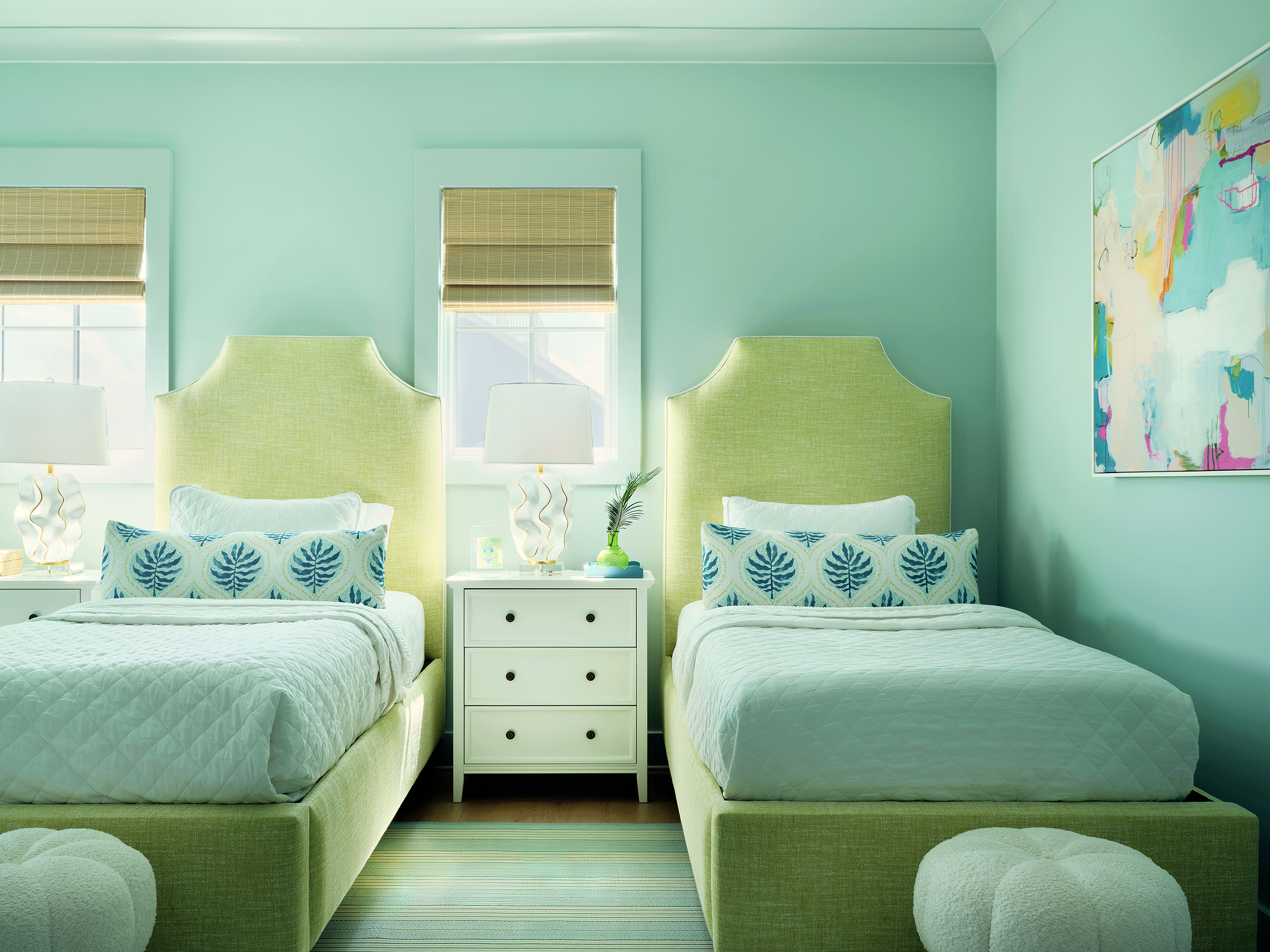 Beach house kids' bedroom featuring twin beds and bright green accents designed for multi-family vacation stays.