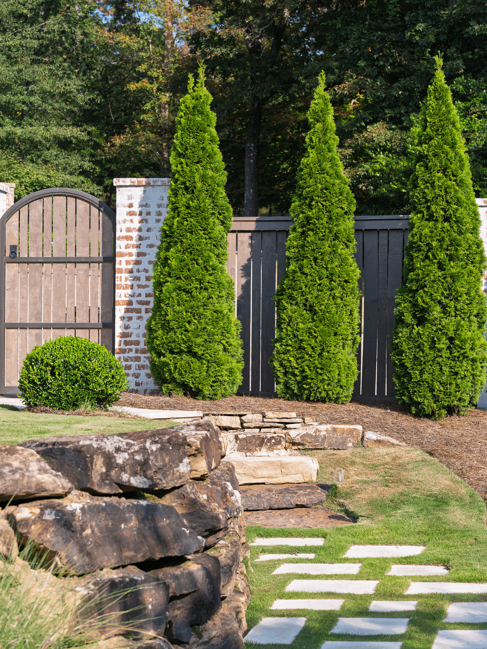 Pool house exterior nestled among mature trees on a wooded residential lot in Mountain Brook, Alabama.