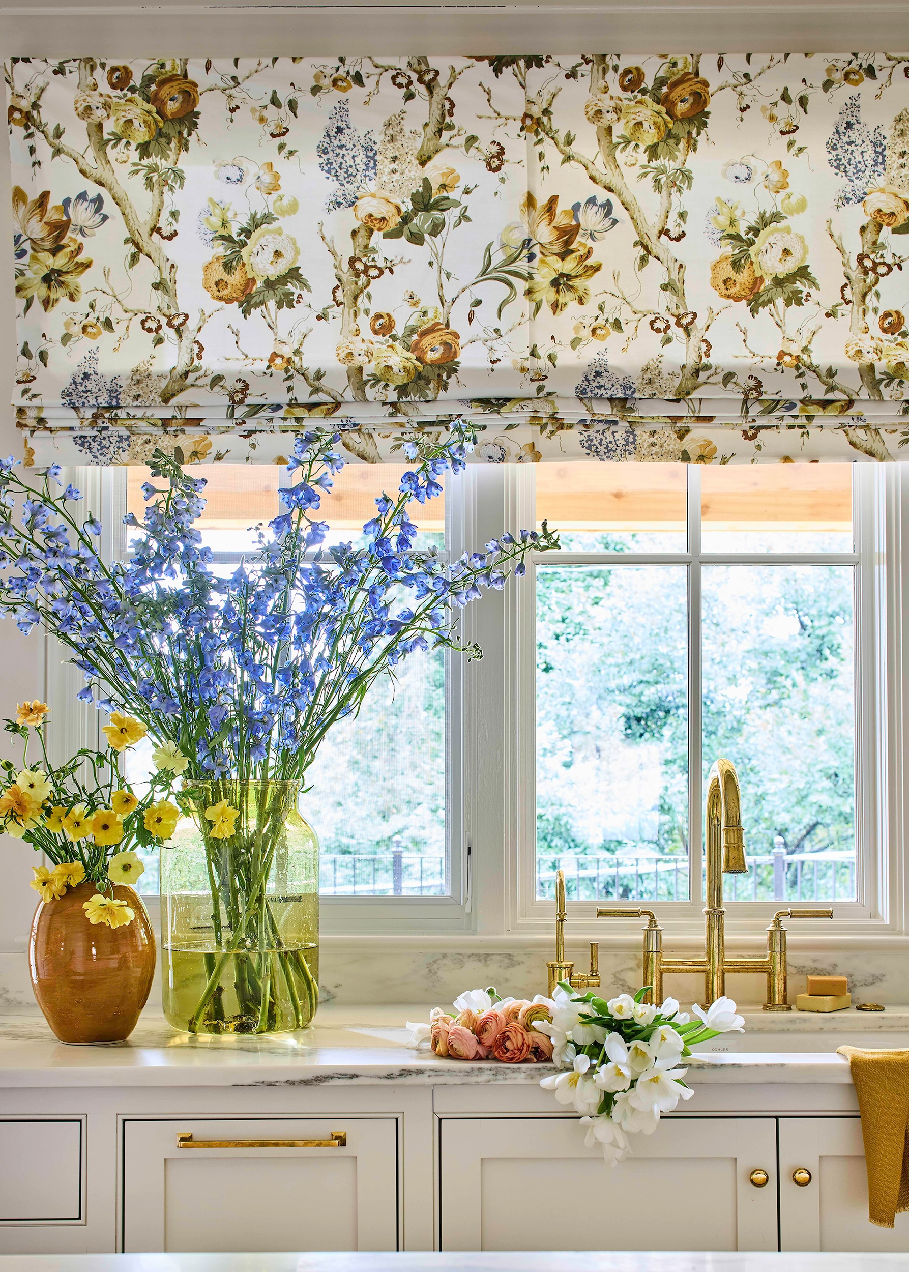 Kitchen sink wall with Alabama white marble countertops and backsplash from Cottage Supply, and a fluted range hood in Kelly Neely interior.