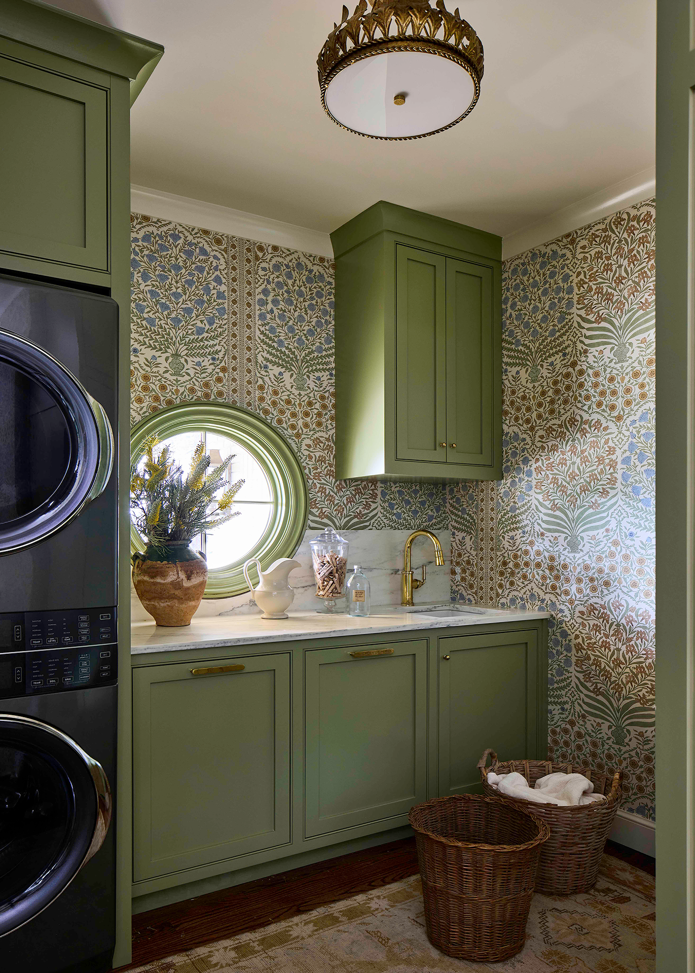 Laundry room wrapped in patterned Kravet wallpaper, tied by color to the adjoining kitchen and breakfast nook by Kelly Neely.