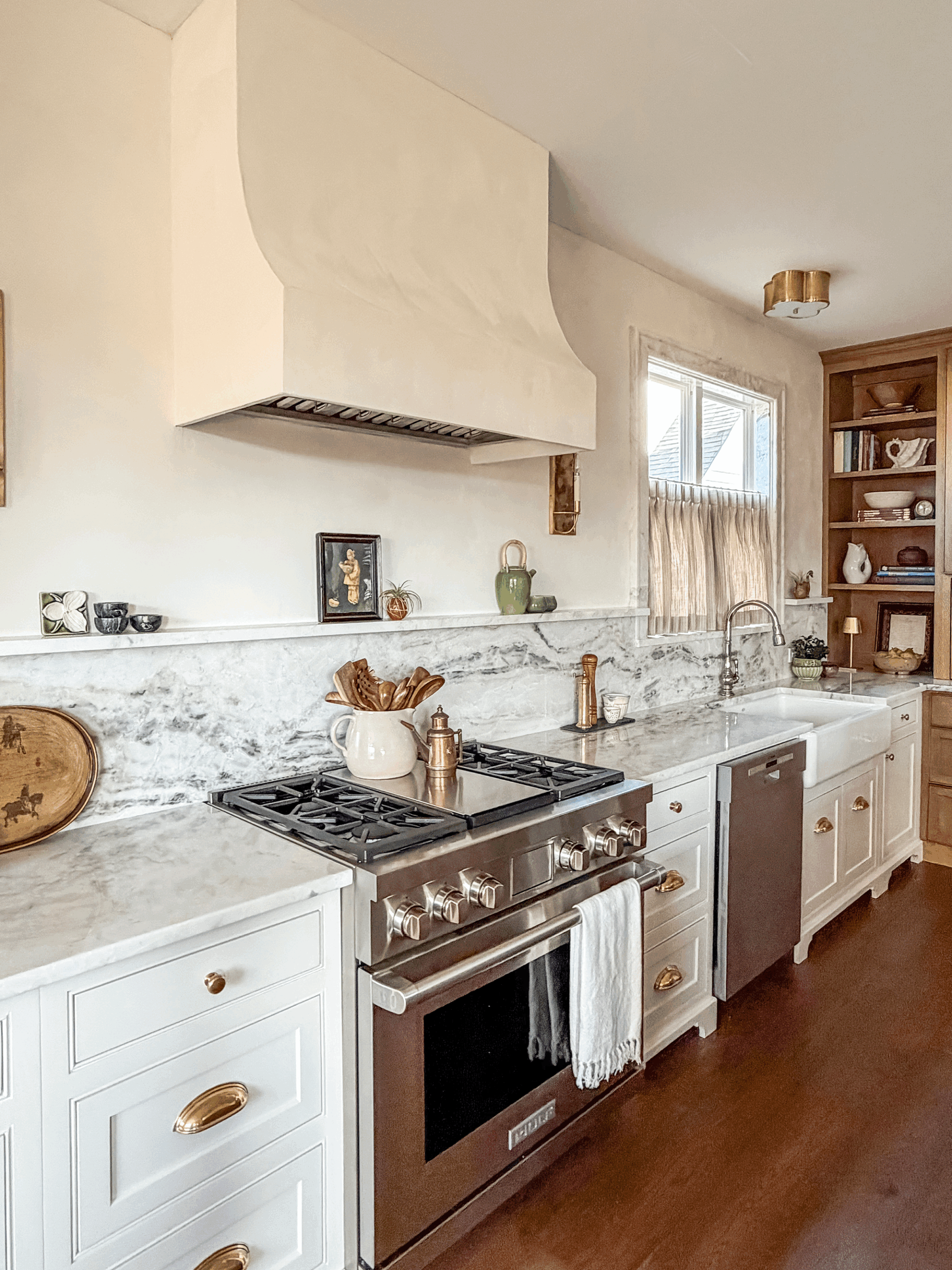 Evolved white kitchen design with zellige backsplash tile and custom range hood