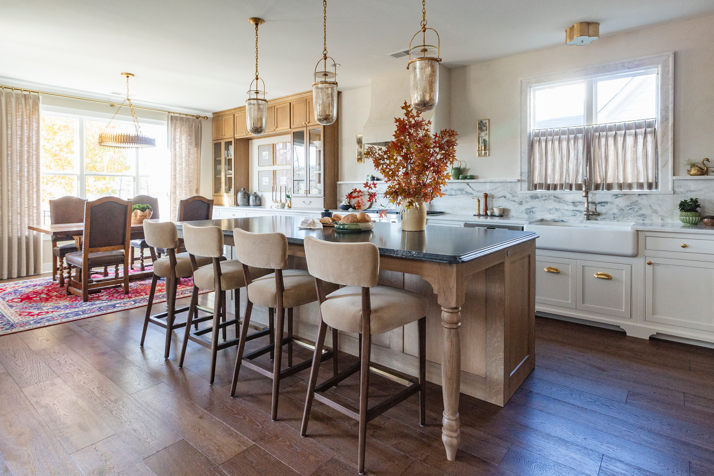 White kitchen cabinetry paired with custom wood dining nook cabinets creating a warm color contrast
