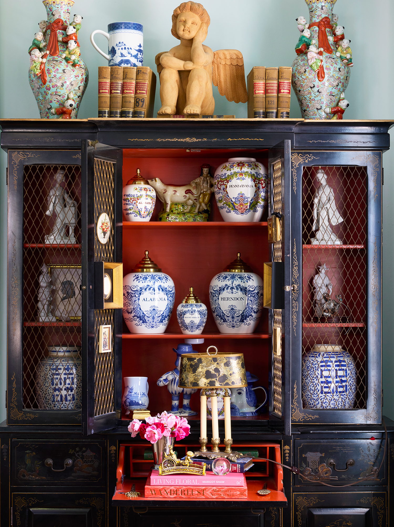 Vintage china cabinet filled with curated heirloom dinnerware and porcelain collectibles inside a Georgian family house.