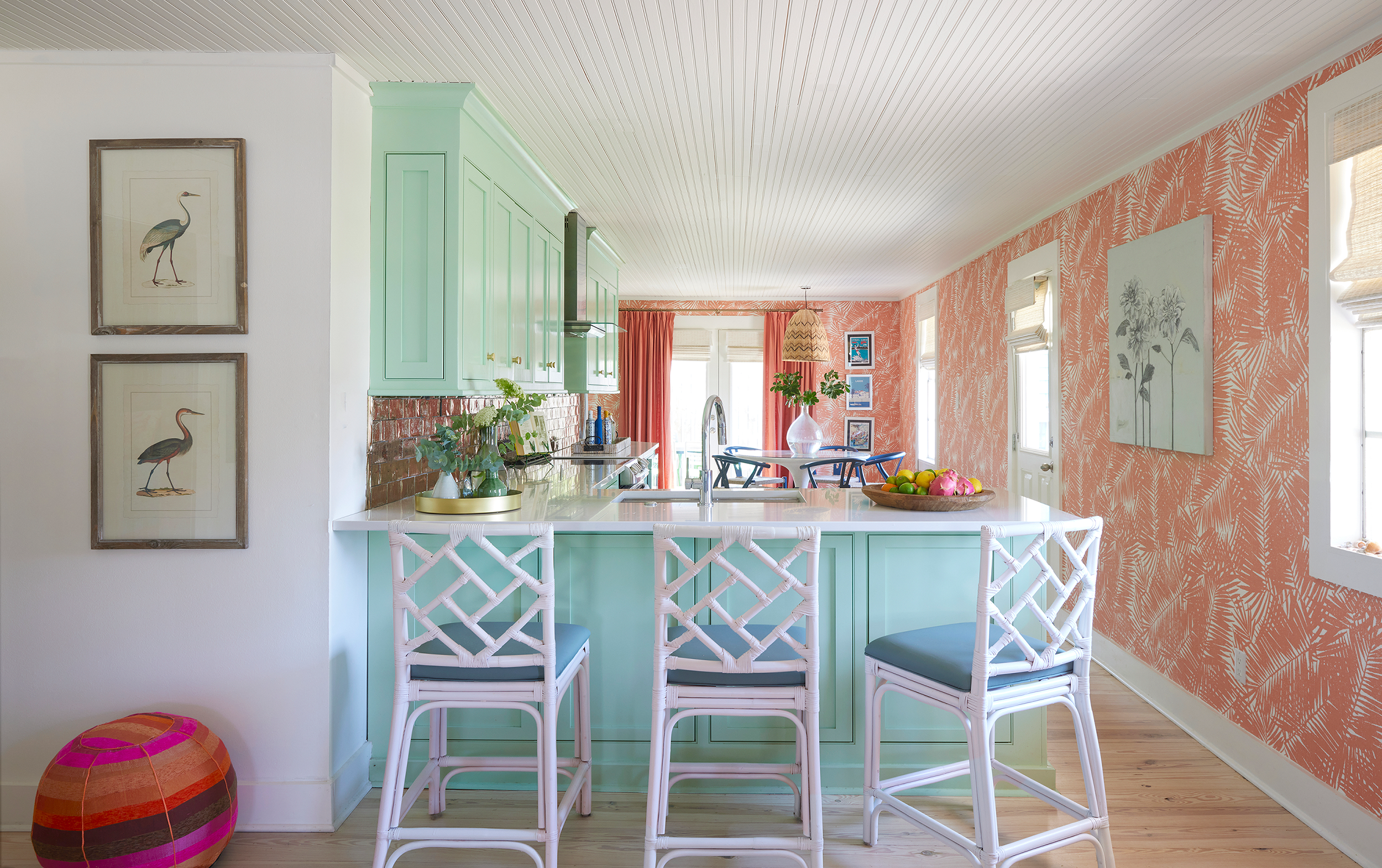 Open-concept Panama City Beach bungalow interior with coral wallpaper, natural light, and relaxed sitting area.