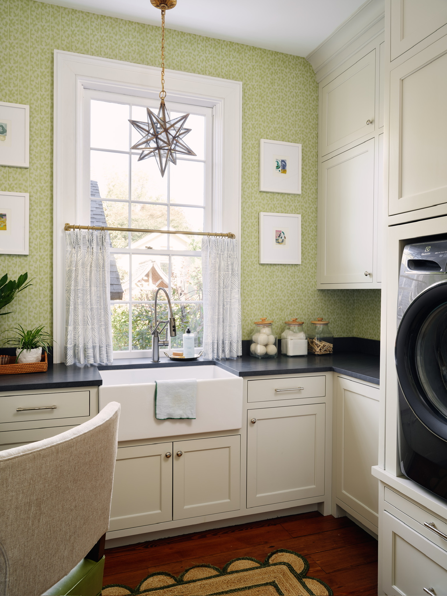 Kelly Butler laundry room design with green wallpaper, star pendant light, and scalloped jute rug.