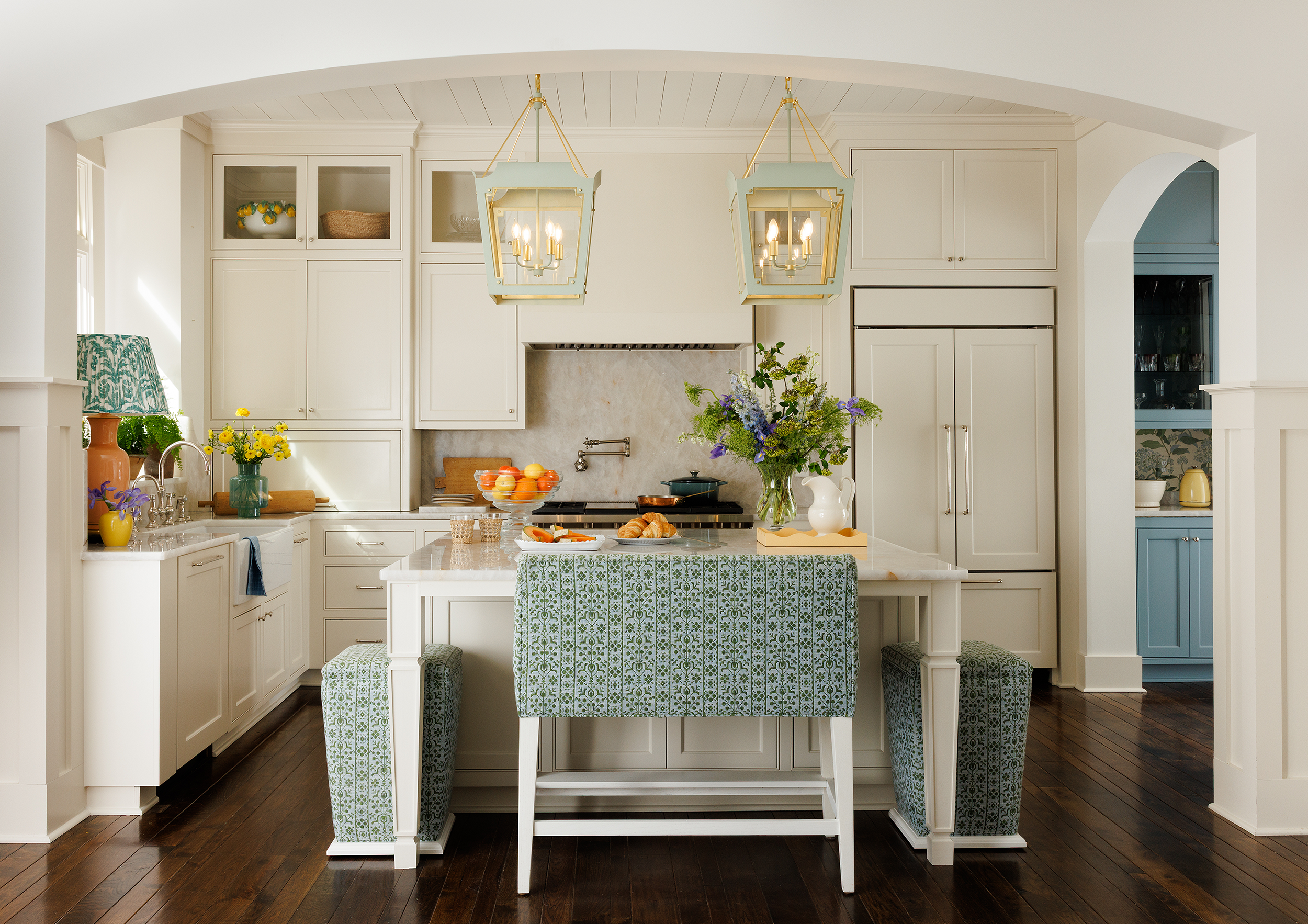 Kitchen island styled with melon, croissants, and morning light near a farmhouse sink in Mountain Brook