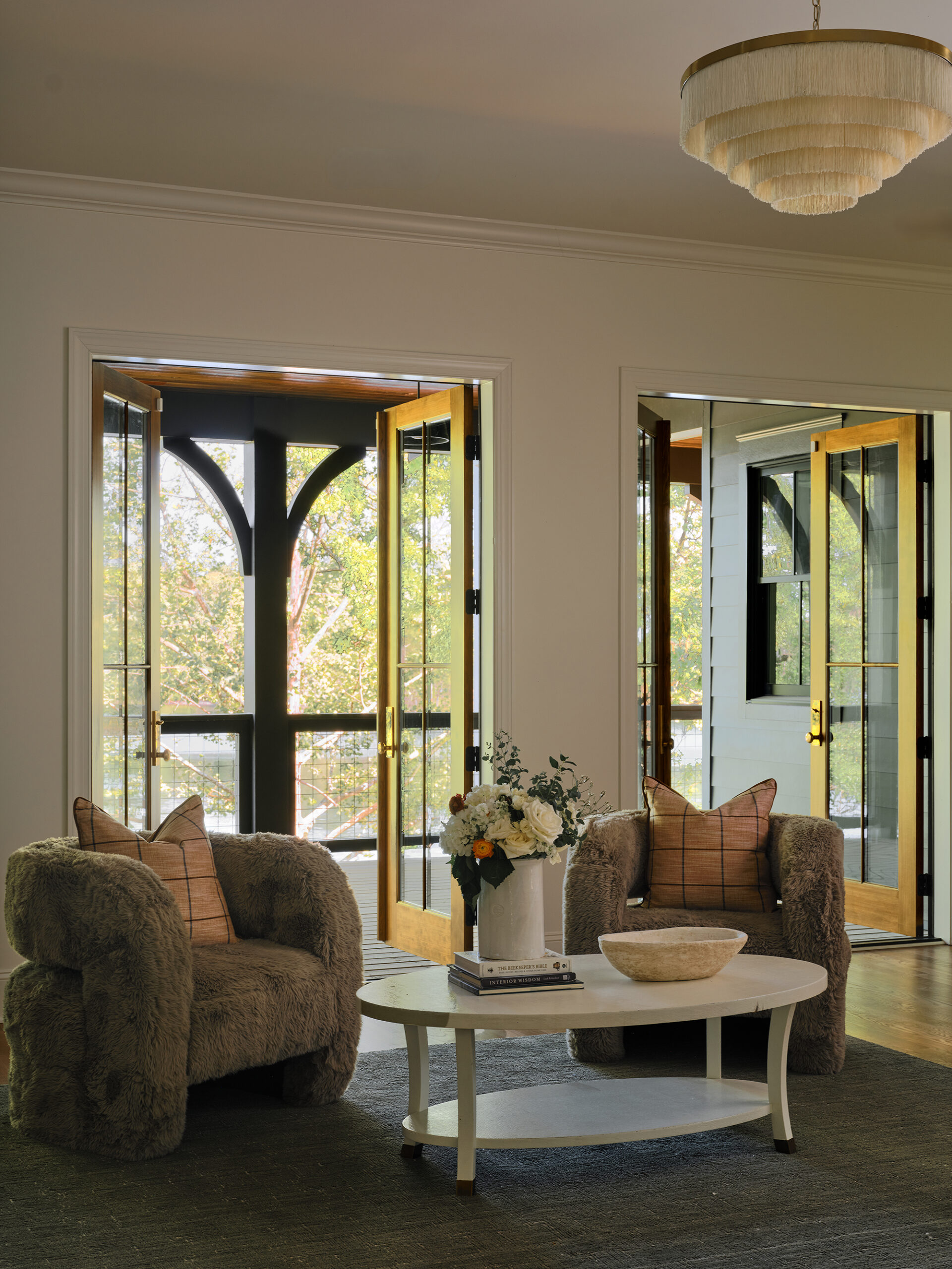 Pair of neutral upholstered armchairs by a sunlit window in a timeless Lake Martin home living space.