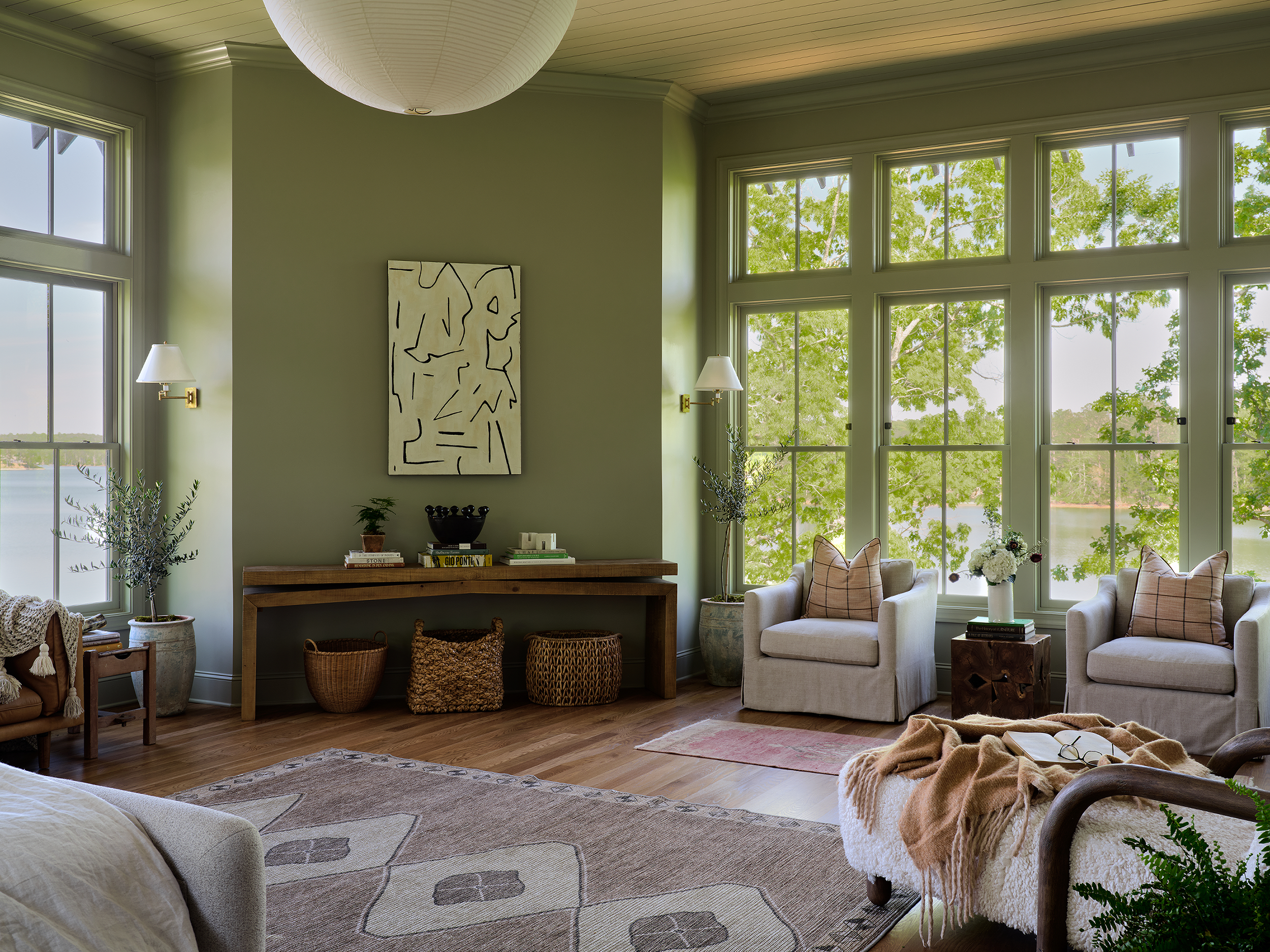 Painted in Farrow & Ball’s French Gray, this Lake Martin primary bedroom takes a quiet approach, allowing the expansive windows and views to command attention