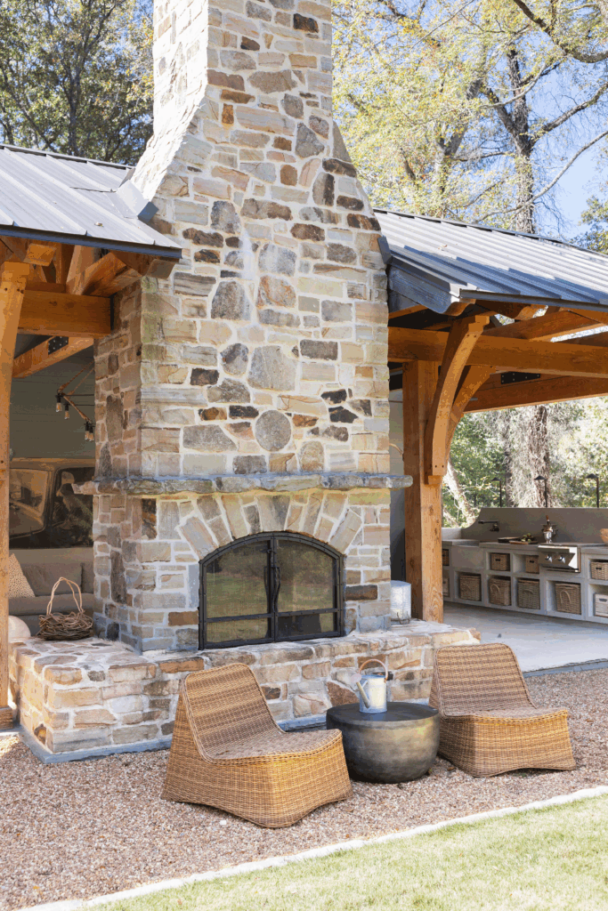 Outdoor living room centered around a stone double-sided fireplace on a Mountain Brook covered terrace.