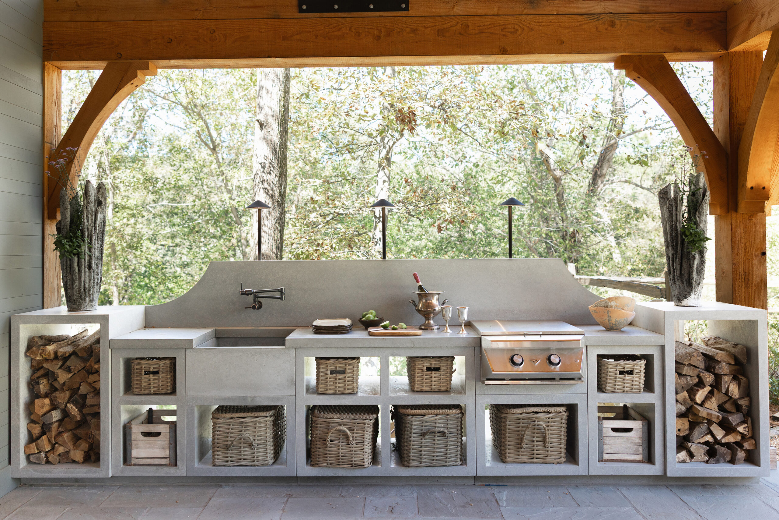 Custom concrete outdoor kitchen and island with woven baskets in a Mountain Brook backyard renovation.